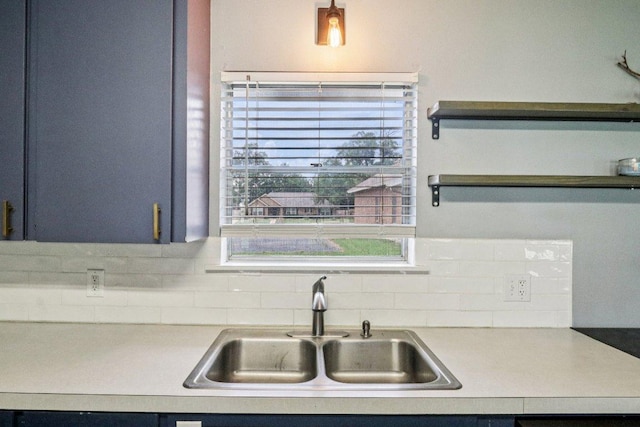 755 E Bellville St, Giddings, TX 78942 - kitchen with light countertops, backsplash, open shelves, and blue cabinets