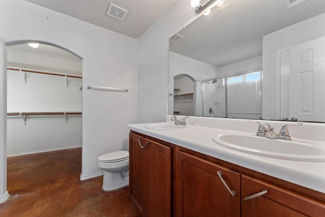 15300 Lucian St, Austin, TX 78725 - bathroom featuring finished concrete floors, double vanity, a shower with shower door, and a walk in closet