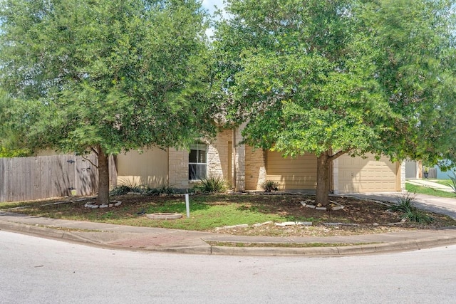 15300 Lucian St, Austin, TX 78725 - view of property hidden behind natural elements with concrete driveway and an attached garage