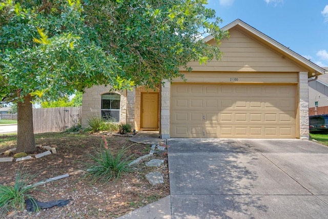 15300 Lucian St, Austin, TX 78725 - view of front facade with concrete driveway, an attached garage, and stone siding