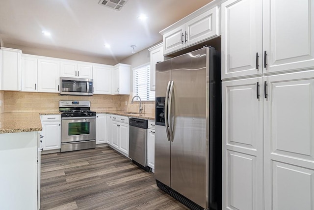 8312 Roan Ln, Austin, TX 78736 - kitchen featuring stainless steel appliances, white cabinets, dark wood-style flooring, decorative backsplash, and recessed lighting