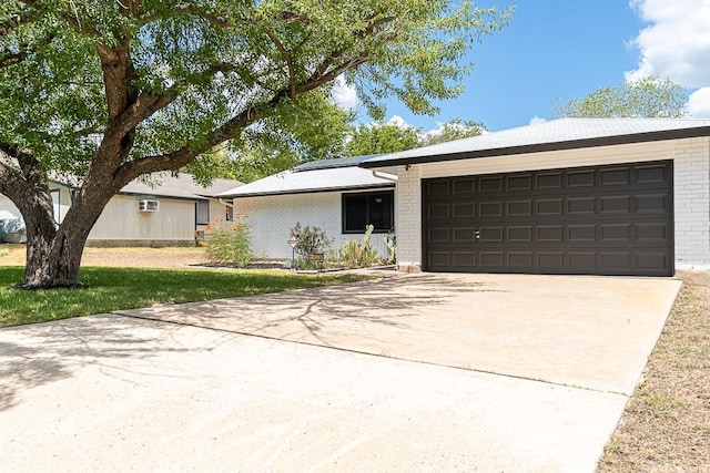 8312 Roan Ln, Austin, TX 78736 - view of front facade featuring brick siding, driveway, a garage, and solar panels
