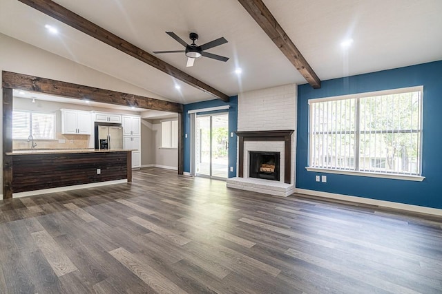 8312 Roan Ln, Austin, TX 78736 - unfurnished living room featuring a ceiling fan, a fireplace, dark wood-style flooring, and healthy amount of natural light