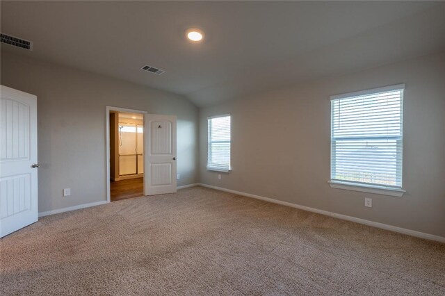 124 Ballyneal Ln, San Marcos, TX 78666 - unfurnished bedroom featuring carpet floors, vaulted ceiling, and ensuite bath