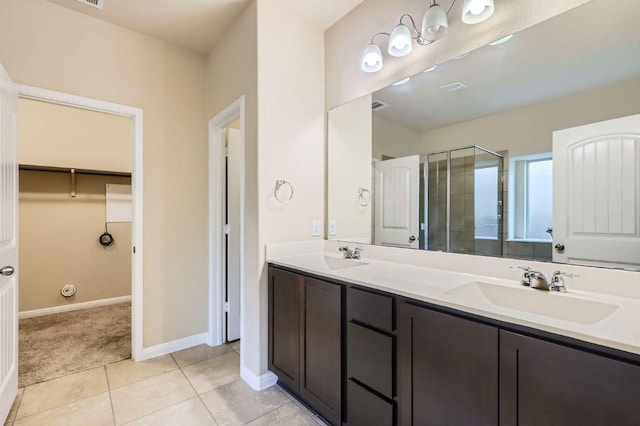 16225 Chianti Cv, Pflugerville, TX 78660 - full bathroom featuring double vanity, a stall shower, tile patterned flooring, and a walk in closet