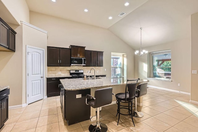 16225 Chianti Cv, Pflugerville, TX 78660 - kitchen with appliances with stainless steel finishes, backsplash, healthy amount of natural light, light tile patterned flooring, and vaulted ceiling