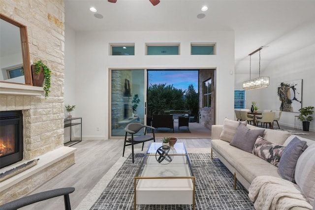 405 Maialina Cv, Lakeway, TX 78738 - living area featuring wood finished floors, ceiling fan, a stone fireplace, a chandelier, and recessed lighting