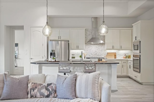 405 Maialina Cv, Lakeway, TX 78738 - kitchen with wall chimney range hood, appliances with stainless steel finishes, open floor plan, backsplash, and white cabinetry
