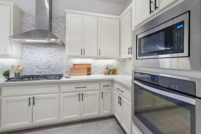 405 Maialina Cv, Lakeway, TX 78738 - kitchen featuring wall chimney exhaust hood, stainless steel appliances, light countertops, white cabinetry, and decorative backsplash