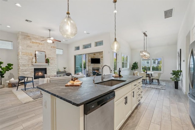 405 Maialina Cv, Lakeway, TX 78738 - kitchen with a fireplace, dishwasher, ceiling fan, dark stone counters, and recessed lighting