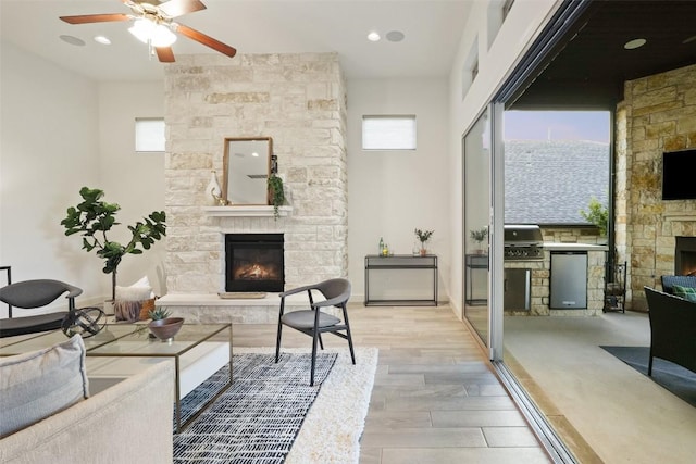 405 Maialina Cv, Lakeway, TX 78738 - living room featuring a stone fireplace, wood finished floors, a ceiling fan, and recessed lighting