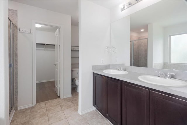 10205 Gertrudis Loop, Austin, TX 78747 - bathroom featuring a shower stall, a walk in closet, double vanity, and tile patterned floors