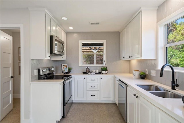19426 Fisher Ln, Spicewood, TX 78669 - kitchen with stainless steel appliances, tasteful backsplash, white cabinetry, light countertops, and recessed lighting