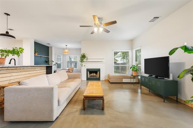903 Thackeray Ln, Pflugerville, TX 78660 - living area featuring healthy amount of natural light, a ceiling fan, concrete flooring, and a fireplace