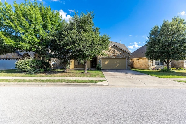 3604 Rosalina Loop, Round Rock, TX 78665 - obstructed view of property featuring an attached garage, driveway, stone siding, and a front lawn