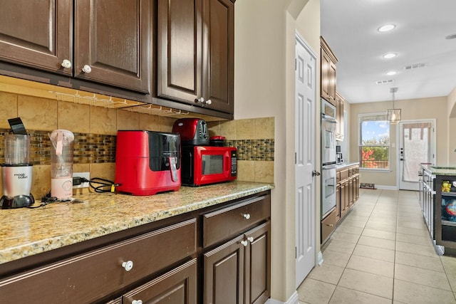 3604 Rosalina Loop, Round Rock, TX 78665 - kitchen with light tile patterned floors, dark brown cabinetry, arched walkways, backsplash, and recessed lighting