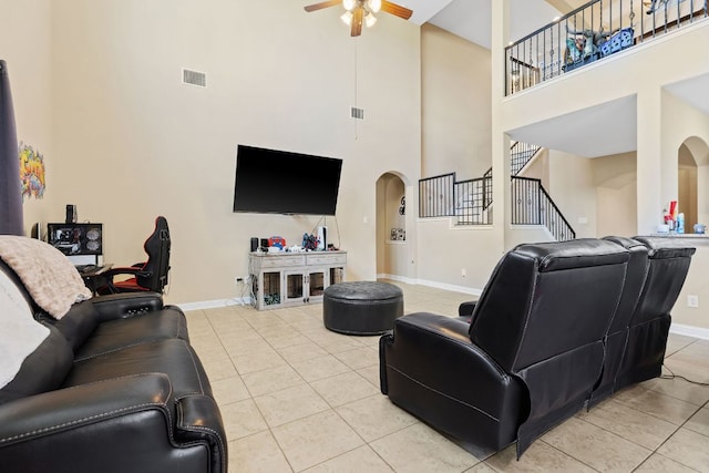 3604 Rosalina Loop, Round Rock, TX 78665 - living area featuring a towering ceiling, arched walkways, ceiling fan, light tile patterned floors, and stairs