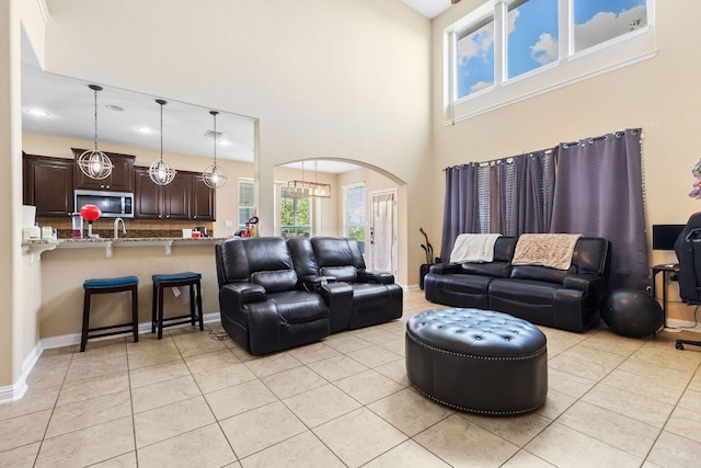 3604 Rosalina Loop, Round Rock, TX 78665 - living room with arched walkways, a high ceiling, light tile patterned floors, and recessed lighting