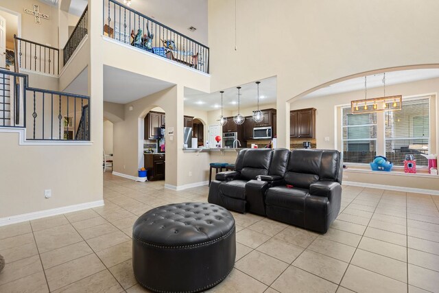 3604 Rosalina Loop, Round Rock, TX 78665 - living area with light tile patterned flooring, arched walkways, a high ceiling, and a chandelier