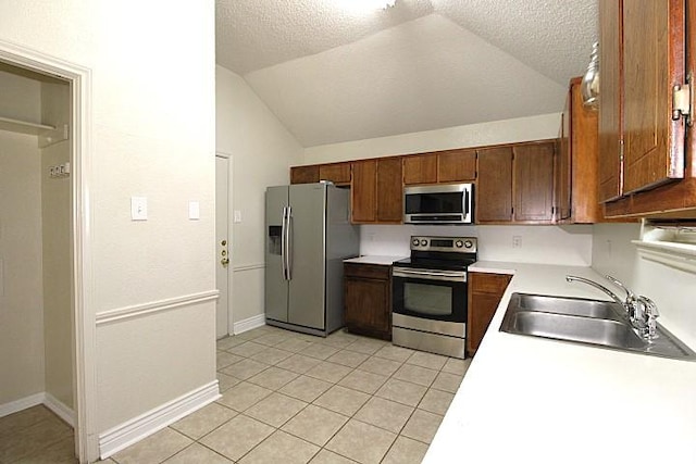213 Bronc Dr, Copperas Cove, TX 76522 - kitchen featuring appliances with stainless steel finishes, vaulted ceiling, light tile patterned flooring, light countertops, and a textured ceiling