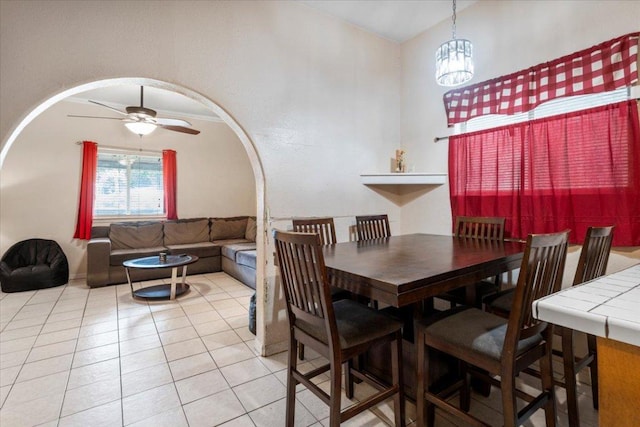 909 W 3rd St, Taylor, TX 76574 - dining area with light tile patterned floors, arched walkways, a ceiling fan, and a chandelier
