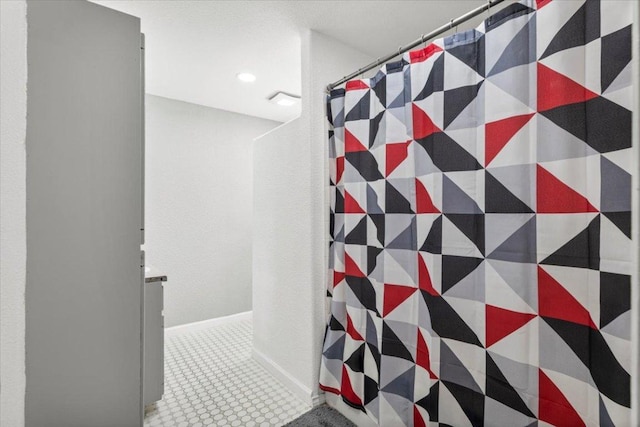 909 W 3rd St, Taylor, TX 76574 - bathroom featuring a shower with curtain and a textured wall