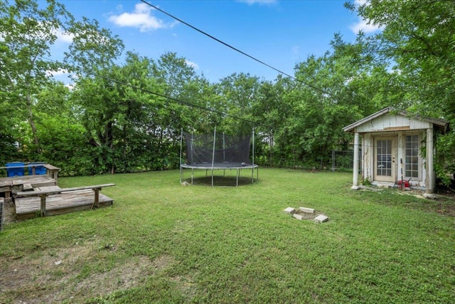 909 W 3rd St, Taylor, TX 76574 - view of green lawn with a trampoline and an outdoor structure