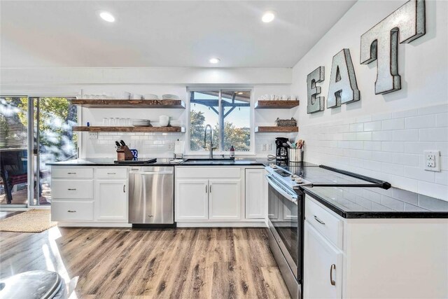 10902 Beach Rd, Leander, TX 78641 - kitchen with open shelves, appliances with stainless steel finishes, dark countertops, decorative backsplash, and white cabinetry