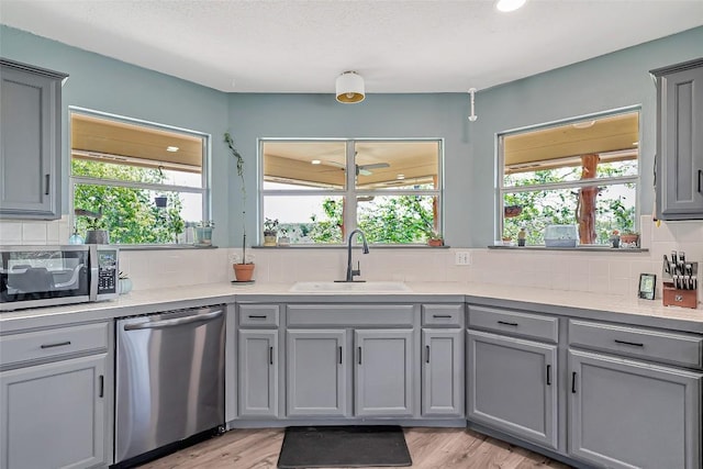 255 Mesquite Dr, Cedar Creek, TX 78612 - kitchen featuring stainless steel appliances, gray cabinets, ceiling fan, and tasteful backsplash