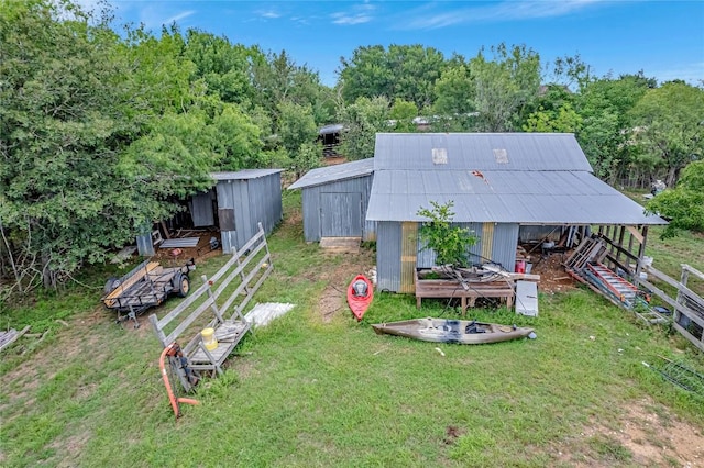 255 Mesquite Dr, Cedar Creek, TX 78612 - view of green lawn with an outbuilding, a view of trees, and a fire pit