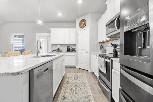 5867 Copano Loop, Belton, TX 76513 - kitchen featuring appliances with stainless steel finishes, tasteful backsplash, an island with sink, white cabinetry, and recessed lighting