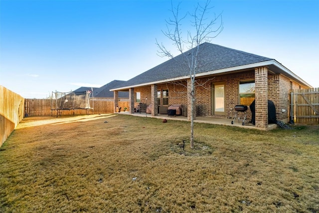5867 Copano Loop, Belton, TX 76513 - back of property with a trampoline, a patio, a fenced backyard, and brick siding