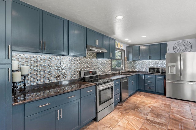 362 Oak Haven Rd, Fredericksburg, TX 78624 - kitchen with stainless steel appliances, under cabinet range hood, tasteful backsplash, dark stone counters, and blue cabinets