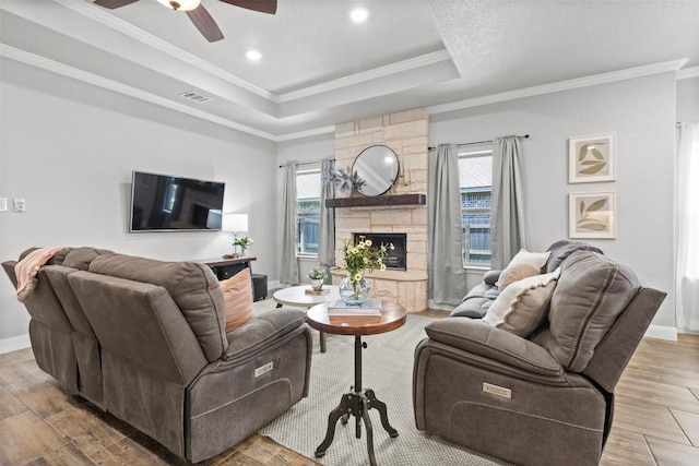 7516 Hardin Dr, Temple, TX 76502 - living area featuring ornamental molding, a tray ceiling, a ceiling fan, a fireplace, and wood finished floors