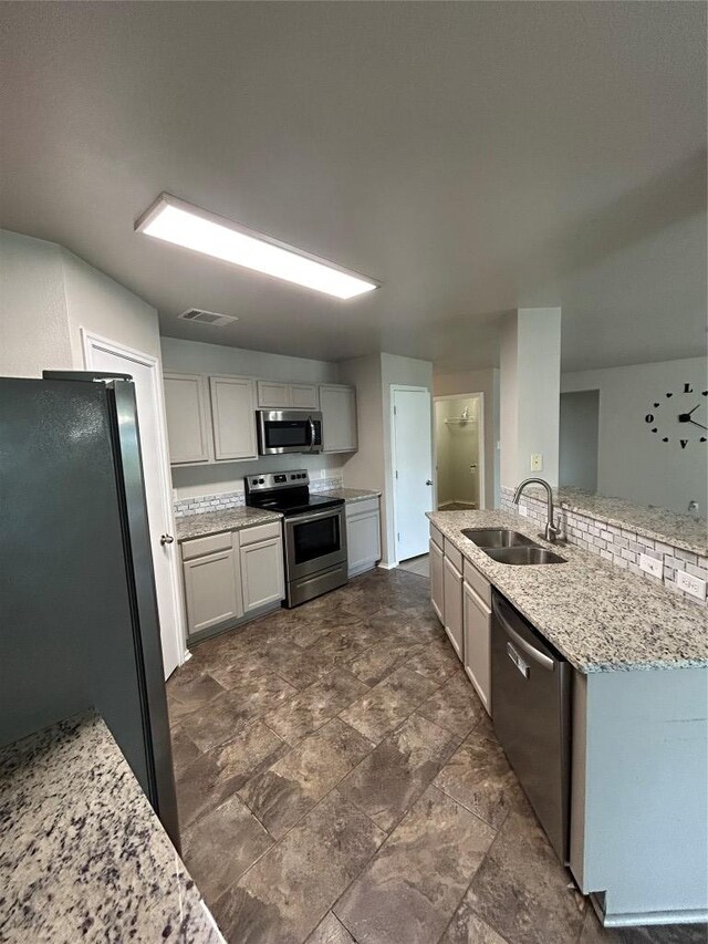 2101 Whistling Way, Taylor, TX 76574 - kitchen with appliances with stainless steel finishes, dark stone finish floors, and light stone counters