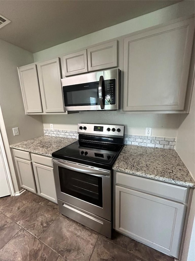 2101 Whistling Way, Taylor, TX 76574 - kitchen with appliances with stainless steel finishes and light stone countertops