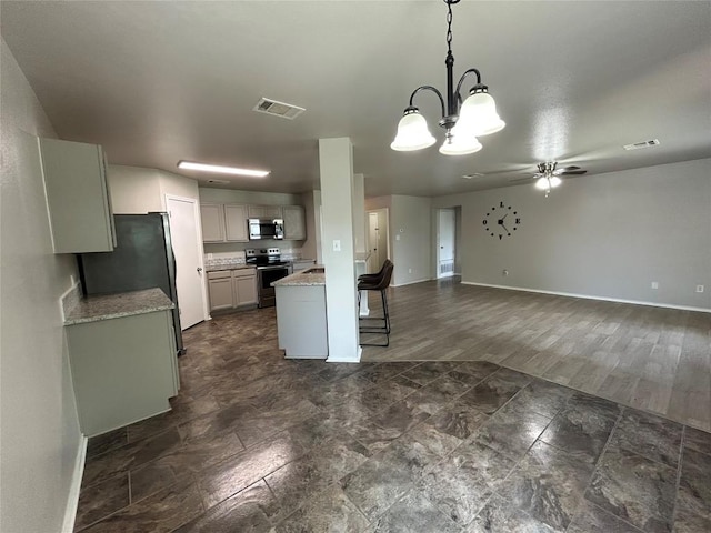 2101 Whistling Way, Taylor, TX 76574 - kitchen with stainless steel appliances, ceiling fan, a chandelier, open floor plan, and pendant lighting