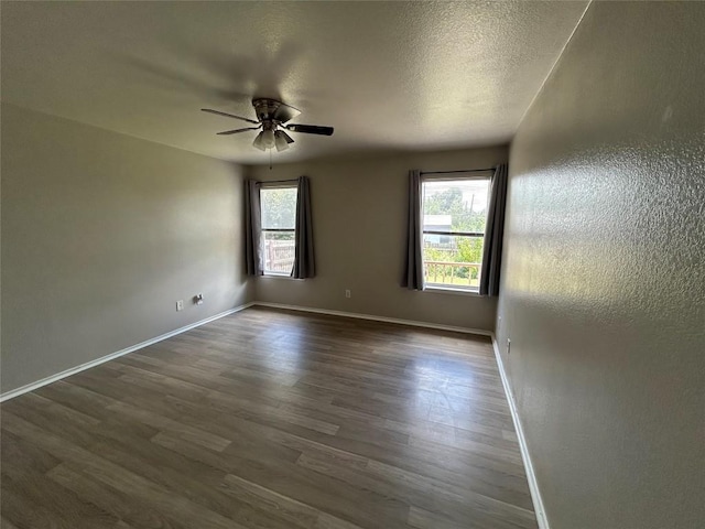 2101 Whistling Way, Taylor, TX 76574 - spare room with healthy amount of natural light, dark wood-style floors, a ceiling fan, and a textured ceiling