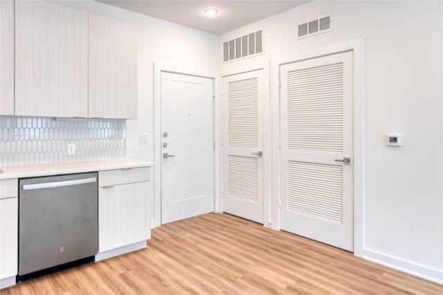 4802 S Congress Ave Unit 217, Austin, TX 78745 - kitchen featuring stainless steel dishwasher, light wood-style floors, light countertops, backsplash, and modern cabinets