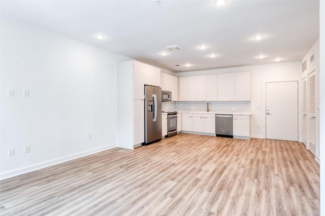 4802 S Congress Ave Unit 217, Austin, TX 78745 - kitchen featuring appliances with stainless steel finishes, light countertops, light wood-style floors, backsplash, and recessed lighting