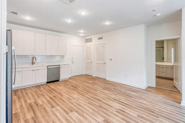 4802 S Congress Ave Unit 217, Austin, TX 78745 - kitchen with appliances with stainless steel finishes, light countertops, decorative backsplash, light wood finished floors, and modern cabinets