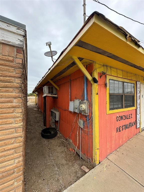 1407 Grand Ave, Big Wells, TX 78830 - view of side of property with a wall mounted AC