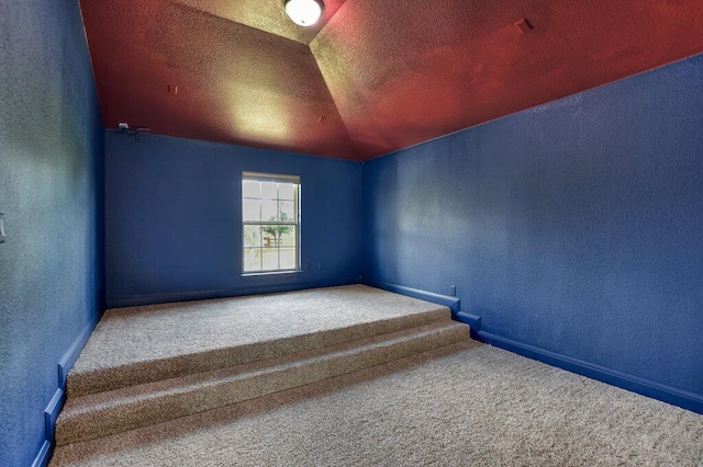2521 Blended Tree Ranch Dr, Leander, TX 78641 - empty room featuring a textured wall, carpet, lofted ceiling, and a textured ceiling