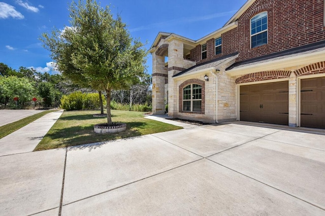 2521 Blended Tree Ranch Dr, Leander, TX 78641 - view of front of house with a front yard, stone siding, an attached garage, and driveway