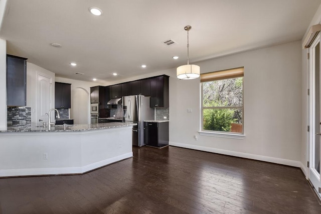 2521 Blended Tree Ranch Dr, Leander, TX 78641 - kitchen featuring stainless steel appliances, backsplash, light stone counters, recessed lighting, and dark wood-style floors