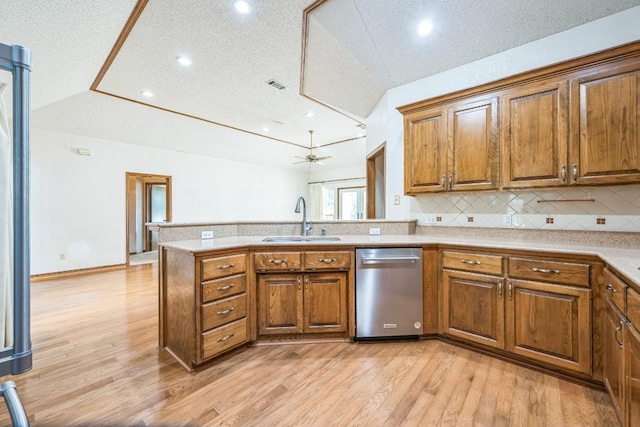 7 Hillway Dr, Round Rock, TX 78664 - kitchen featuring dishwasher, brown cabinets, a peninsula, light wood-style flooring, and lofted ceiling