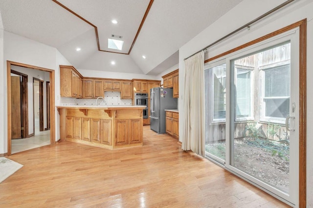 7 Hillway Dr, Round Rock, TX 78664 - kitchen with stainless steel appliances, a peninsula, a skylight, light countertops, and a kitchen bar