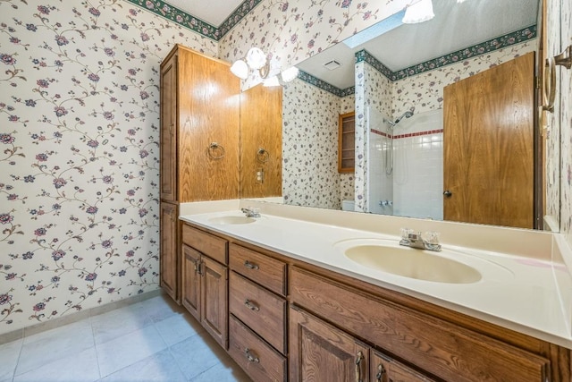 7 Hillway Dr, Round Rock, TX 78664 - bathroom with wallpapered walls, double vanity, and a tile shower