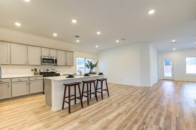 2928 Tantara Dr, Katy, TX 77493 - kitchen with appliances with stainless steel finishes, gray cabinets, healthy amount of natural light, an island with sink, and recessed lighting