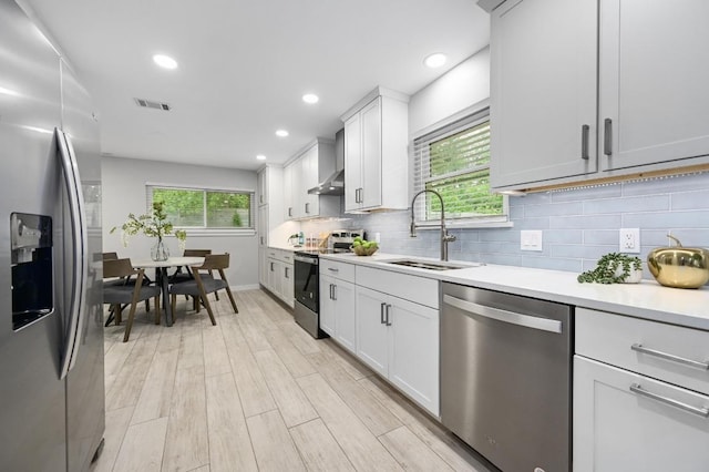 11508 Bell Ave, Austin, TX 78759 - kitchen with stainless steel appliances, light countertops, decorative backsplash, light wood-style flooring, and recessed lighting